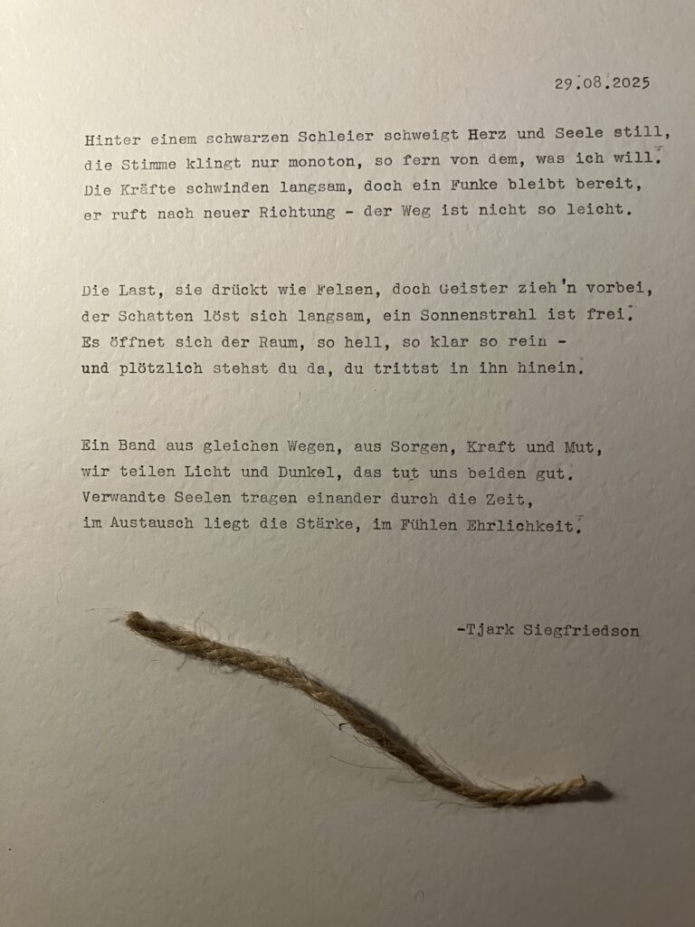 Ein Foto von einem Schreibmaschinen geschriebenen Gedicht, welches 3 Strophen über den Wandel aus Angst und Zurückhaltung zu sich selbst und Energie. Auf dem fotografierten Blatt liegt ein kleines Stück Hanfseil zur Versinnbildlichung des Bandes der Seelenverwandschaft.